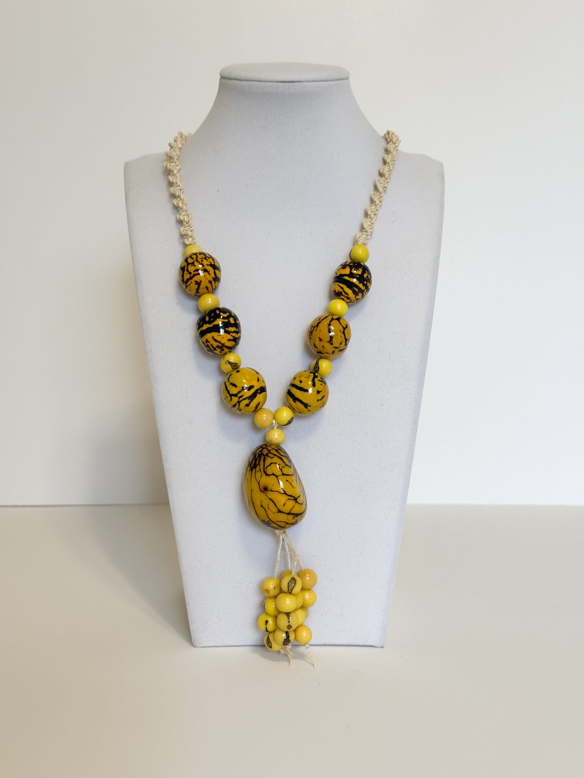 Amazonian Treasures statement necklace featuring yellow jarina beads with black patterns and natural tucum fiber cord.