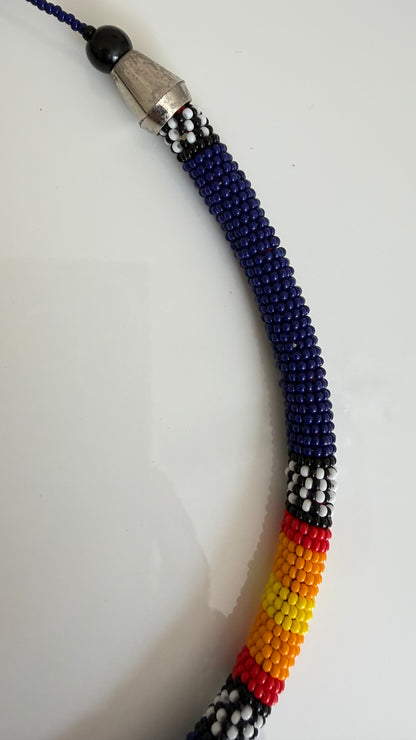 Close-up of royal blue beadwork and colorful banding on 18 inch choker necklace

