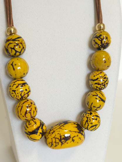 Yellow jarina and paxiúba seed necklace handcrafted with natural Amazon seeds close-up