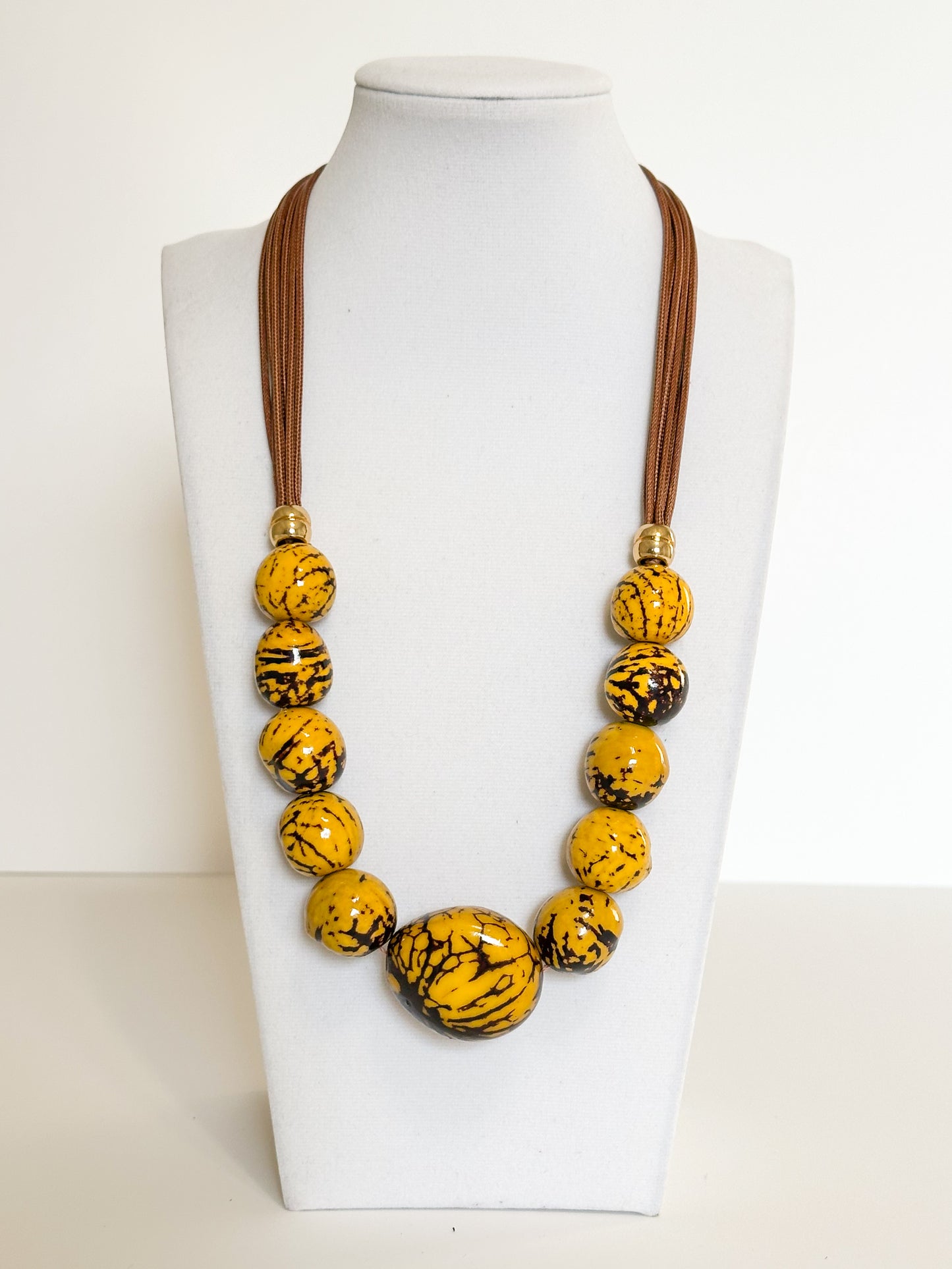Yellow jarina and paxiúba seed necklace handcrafted with natural Amazon seeds.