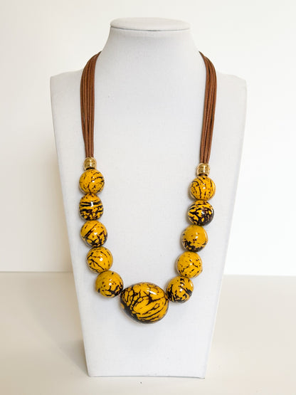 Yellow jarina and paxiúba seed necklace handcrafted with natural Amazon seeds.