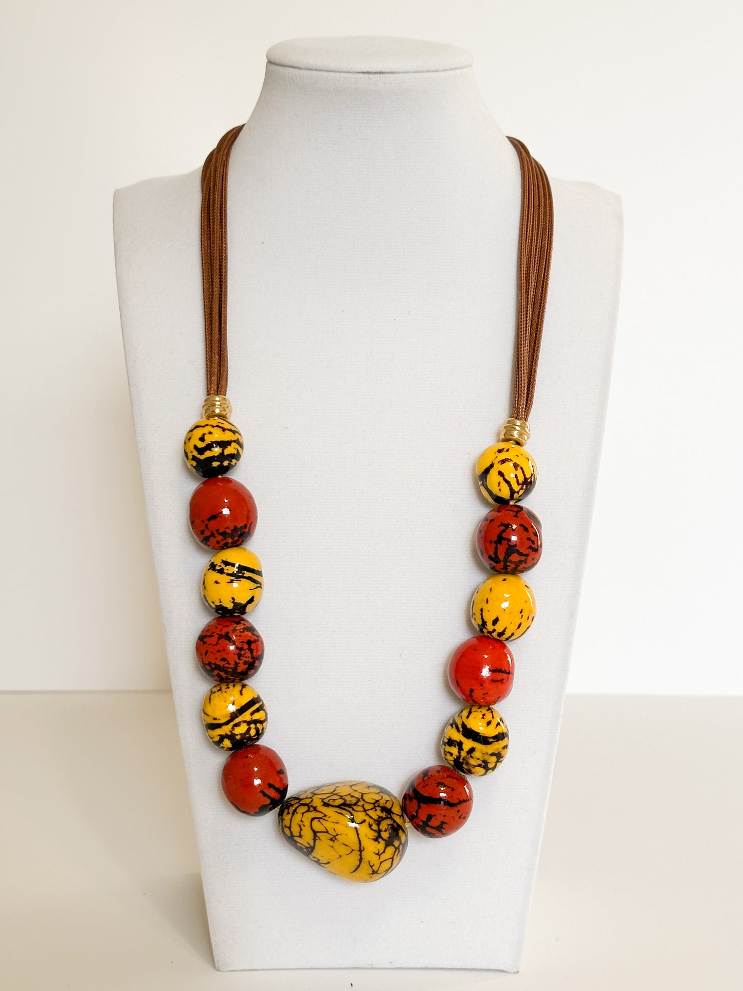 Yellow jand red arina and paxiúba seed necklace handcrafted with natural Amazon seeds.