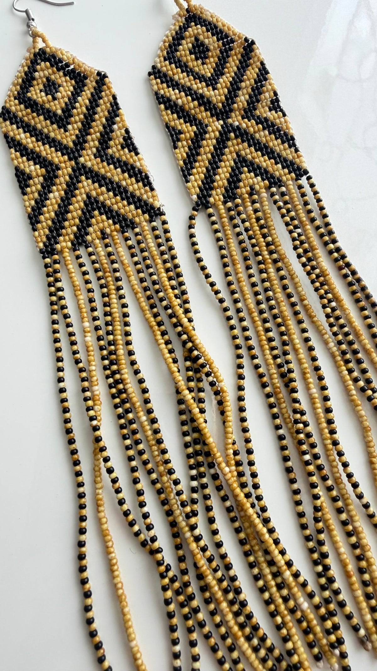Close-up of Wai Wai artisan beadwork on 7 inch fringe earrings from Brazil